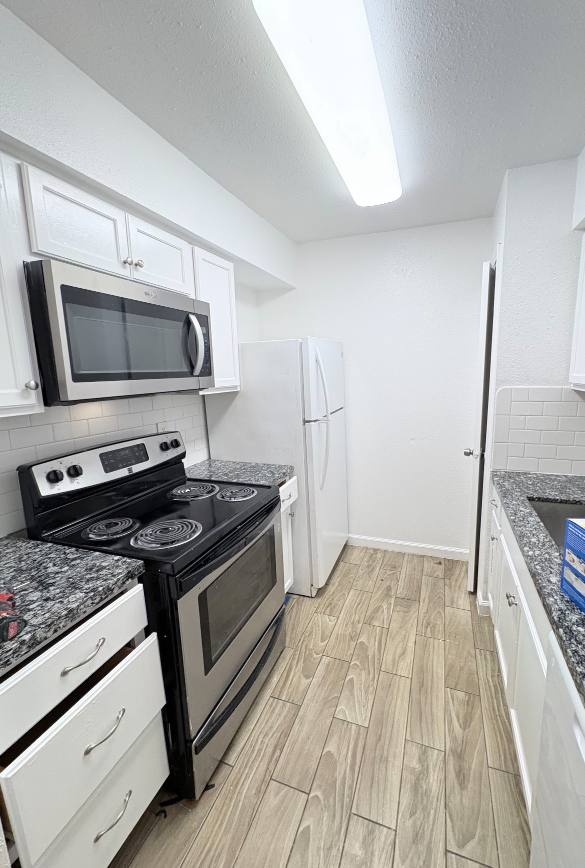 6200 West Tidwell Road West, Unit 1002 Houston, TX 77092 - Photo 3 of 8 a kitchen with a stove and a microwave