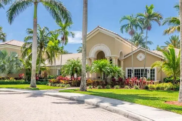 a front view of multiple houses with yard and green space