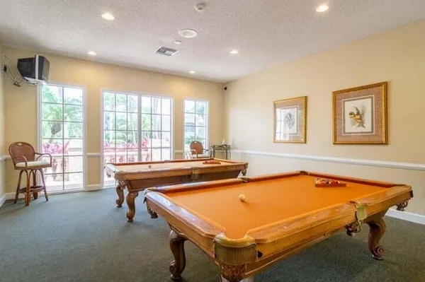 a room with pool table and windows