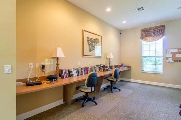a view of a workspace with furniture and a window