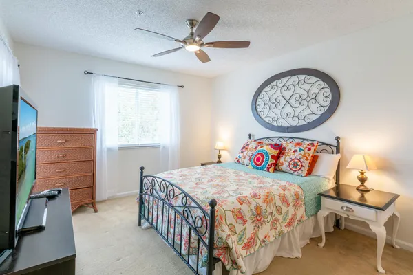 a bedroom with a bed a dresser and a window