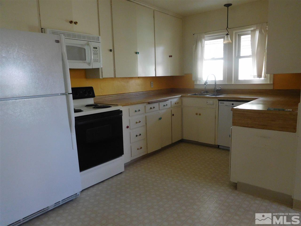 1160 The Strand Reno, NV 89503 - Photo 5 of 14 a kitchen with granite countertop white cabinets and window