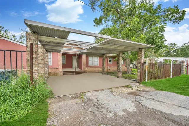 a backyard of a house with table and chairs under an umbrella