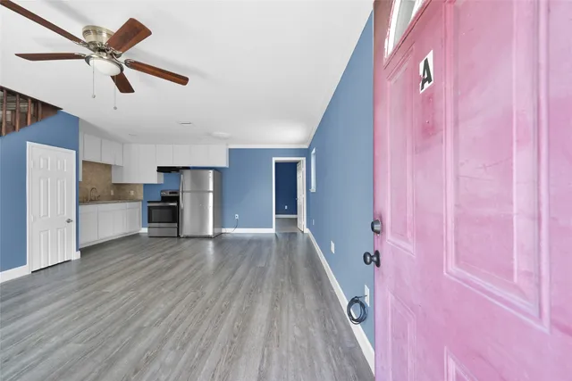 a view of empty room with wooden floor and window