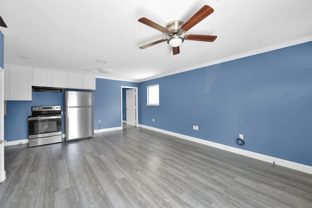 a view of a kitchen with a ceiling fan hardwood floor and a ceiling fan