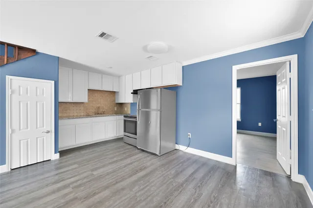 a kitchen with a refrigerator and a stove top oven