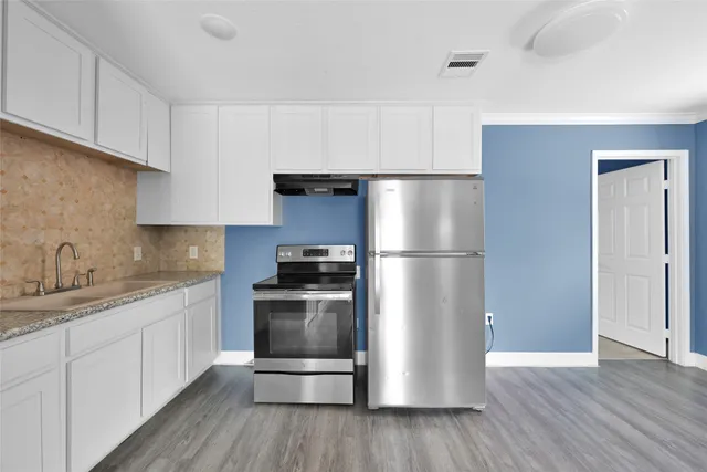a kitchen with a refrigerator sink and wooden floor