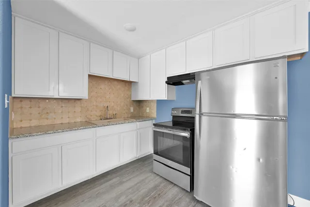 a kitchen with a refrigerator sink and cabinets