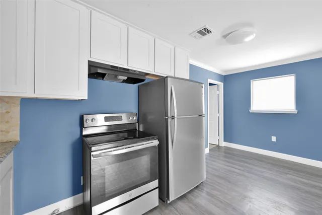 a kitchen with a refrigerator sink and cabinets