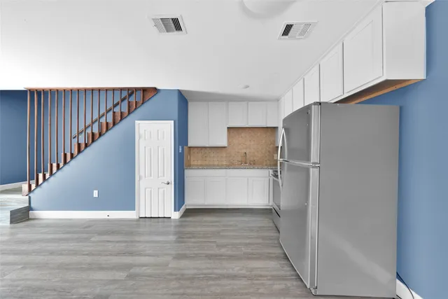 a view of kitchen with wooden floor and electronic appliances