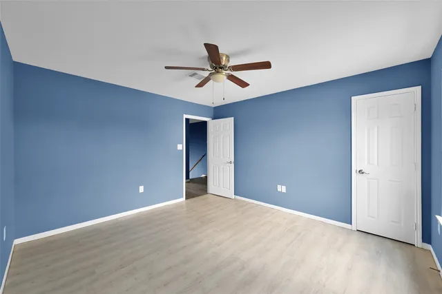 a view of a room with a ceiling fan and carpet