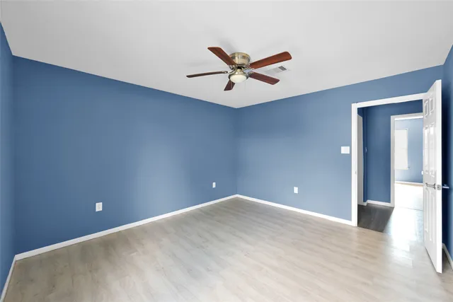 a view of a big room with wooden floor and windows
