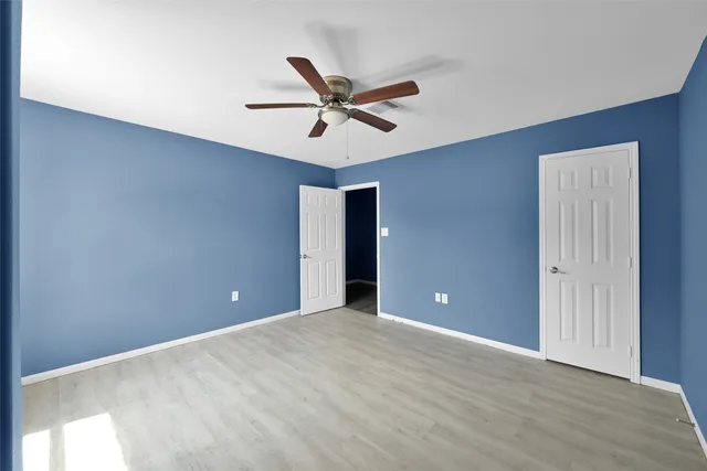 a view of a big room with a ceiling fan and a window