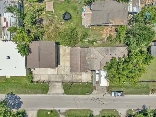 an aerial view of a house with a yard and large tree