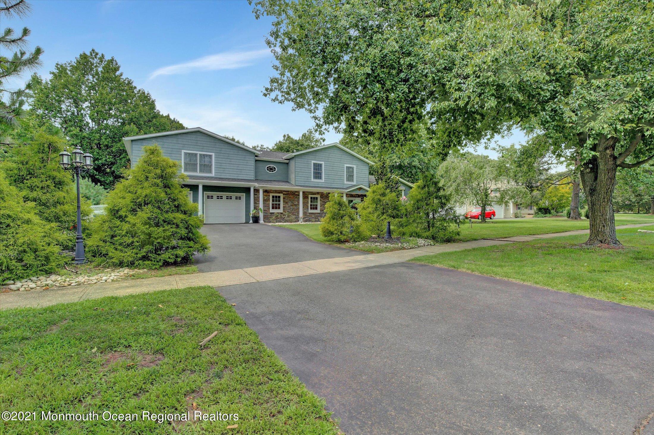 76 Swimming River Road Lincroft, NJ 07738 - Photo 2 of 50 a front view of a house with a yard and trees