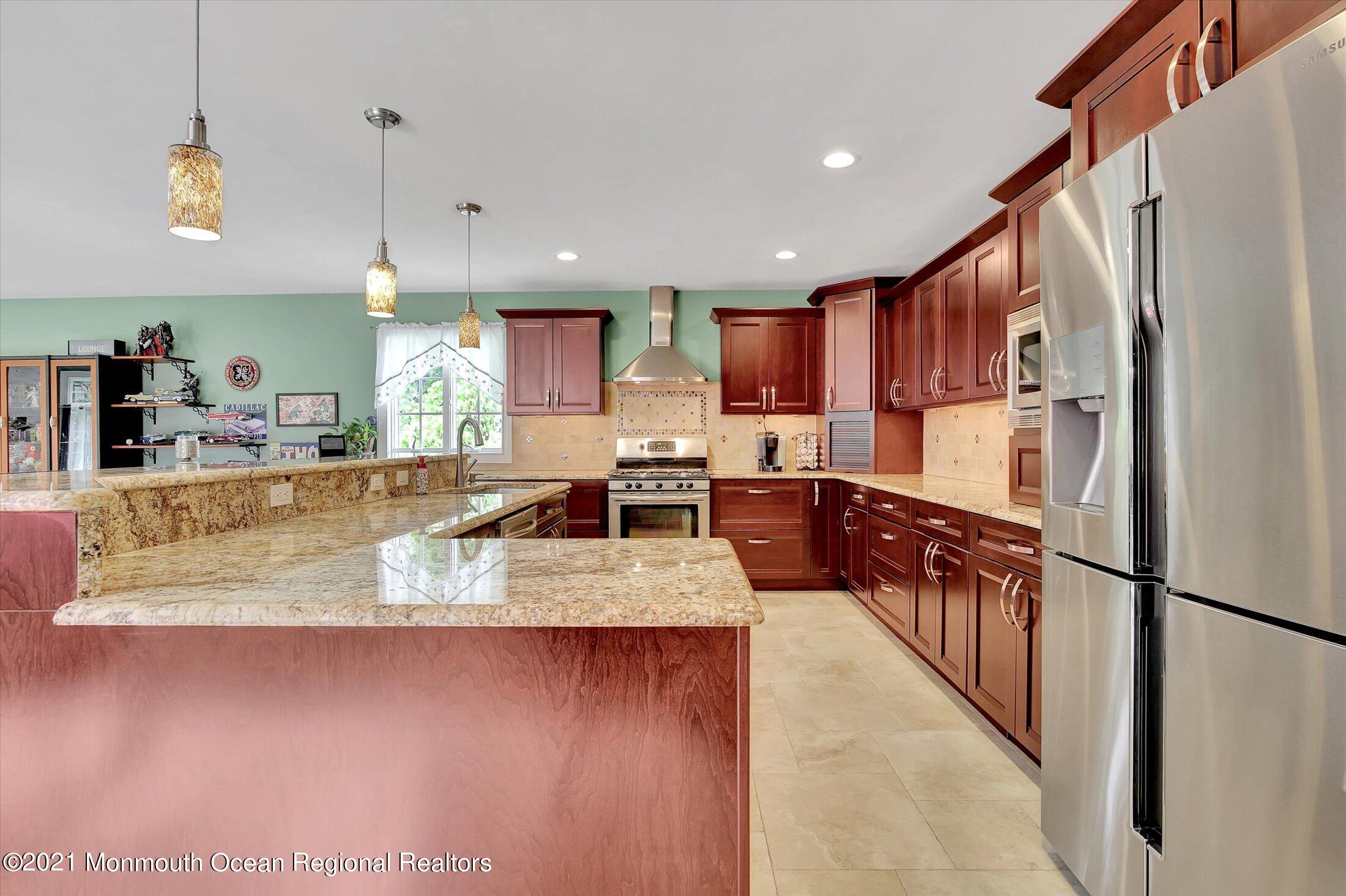 76 Swimming River Road Lincroft, NJ 07738 - Photo 15 of 50 a large kitchen with kitchen island a large counter top stainless steel appliances and cabinets