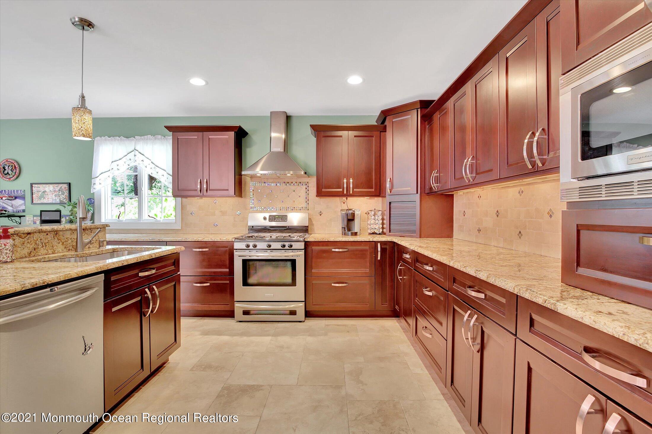76 Swimming River Road Lincroft, NJ 07738 - Photo 16 of 50 a kitchen with stainless steel appliances granite countertop a stove a sink and a refrigerator