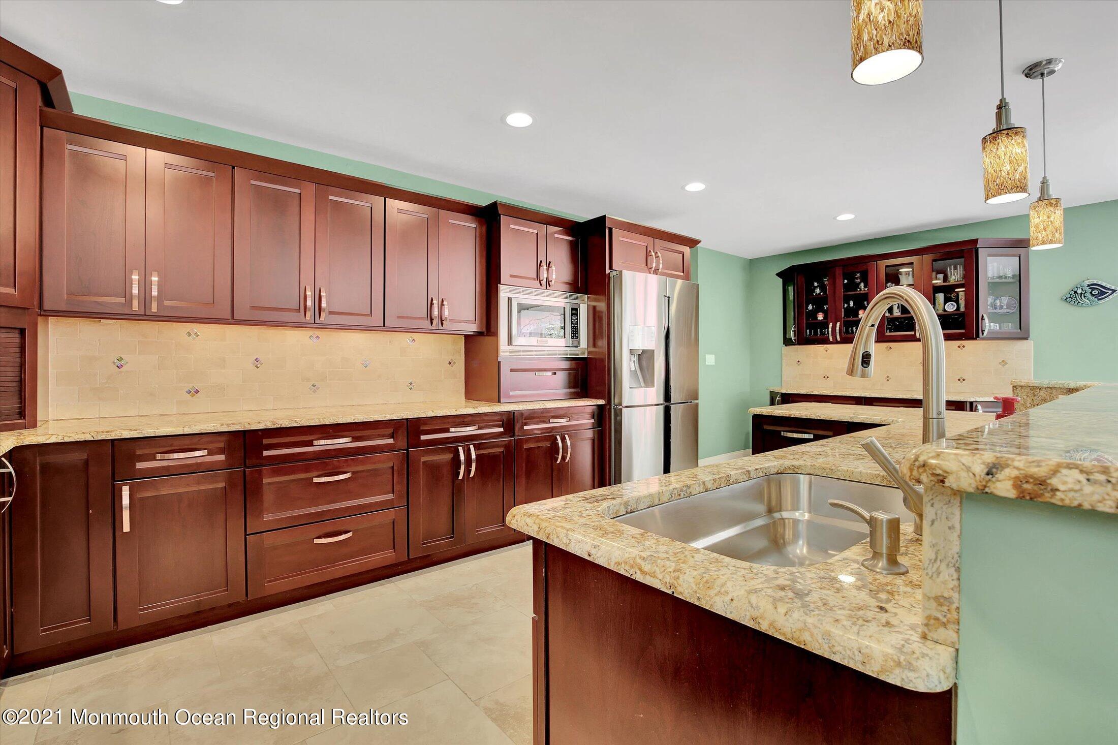 76 Swimming River Road Lincroft, NJ 07738 - Photo 18 of 50 a kitchen with stainless steel appliances granite countertop a sink refrigerator and cabinets