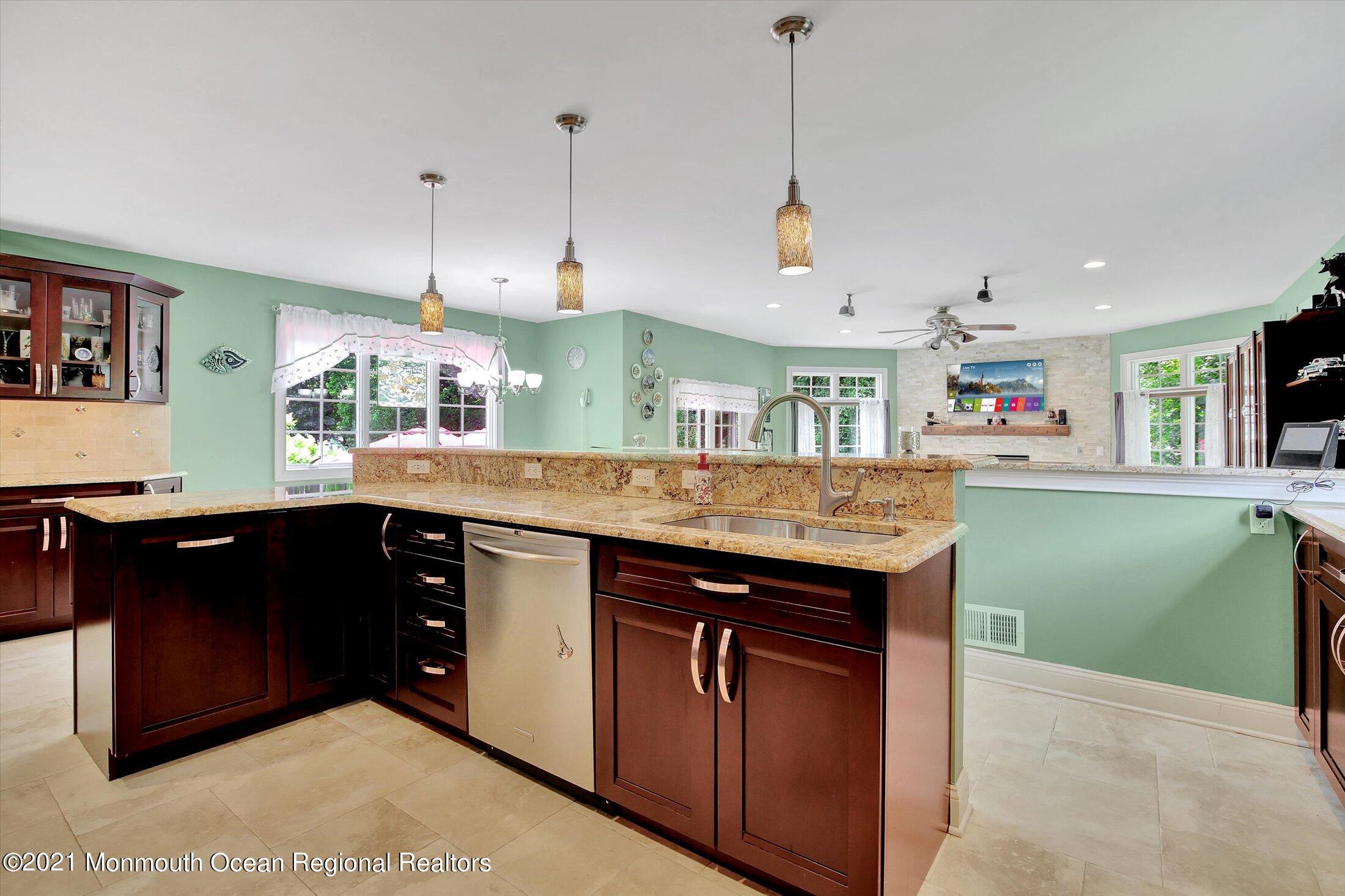 76 Swimming River Road Lincroft, NJ 07738 - Photo 19 of 50 a kitchen with kitchen island a sink and a wooden floor