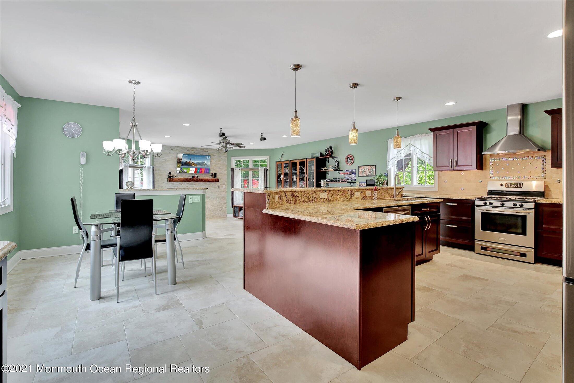 76 Swimming River Road Lincroft, NJ 07738 - Photo 20 of 50 a kitchen with kitchen island granite countertop lots of counter top space and stainless steel appliances