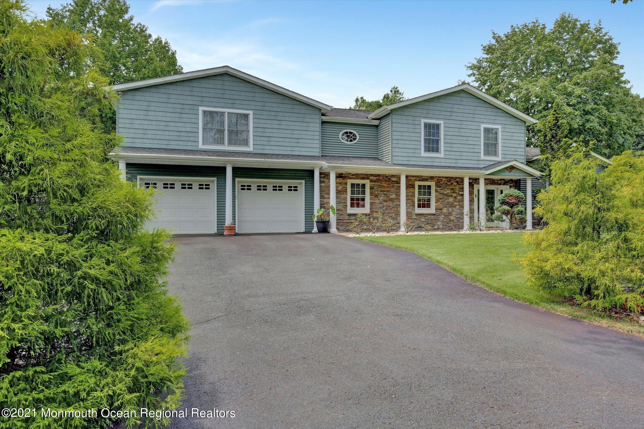 76 Swimming River Road Lincroft, NJ 07738 - Photo 4 of 50 a front view of a house with a garden