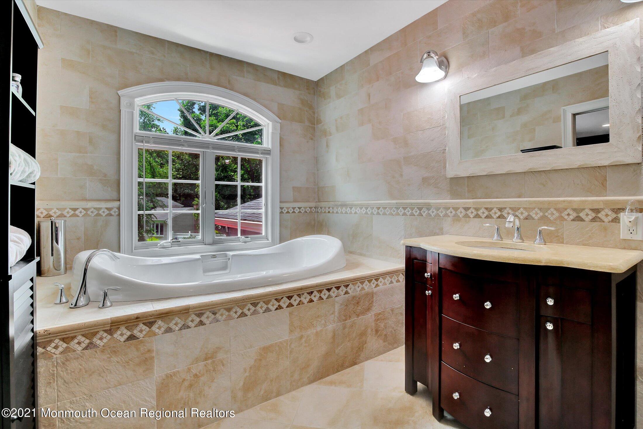 76 Swimming River Road Lincroft, NJ 07738 - Photo 31 of 50 a bathroom with a tub sink and mirror