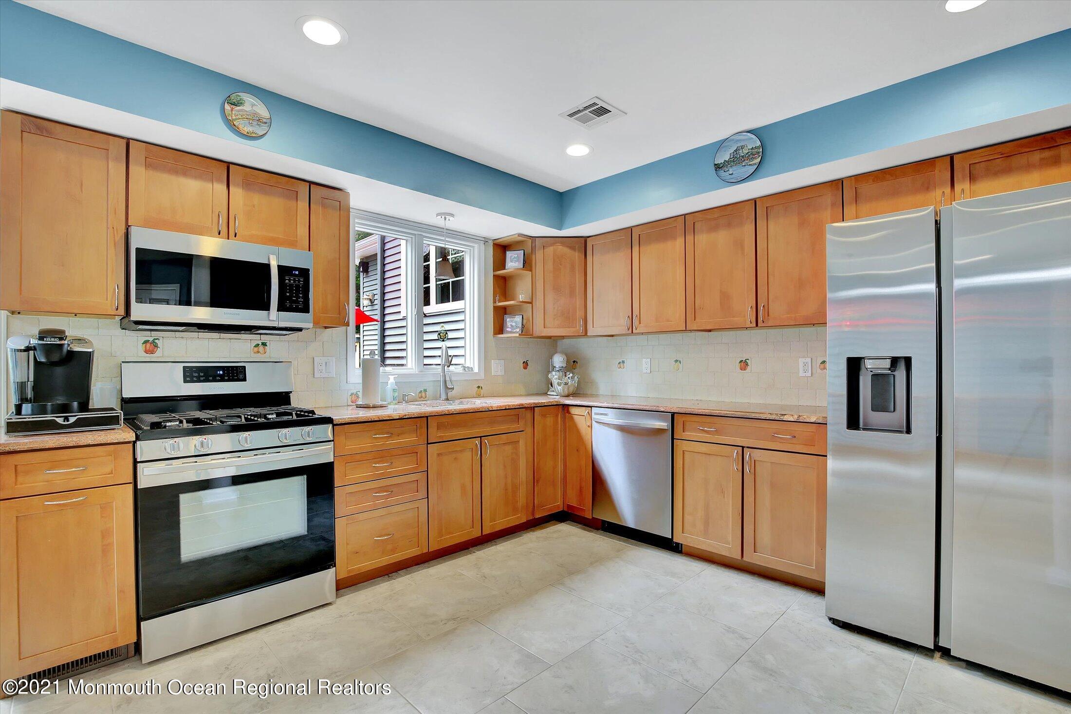76 Swimming River Road Lincroft, NJ 07738 - Photo 40 of 50 a kitchen with stainless steel appliances granite countertop a stove top oven a sink and a refrigerator