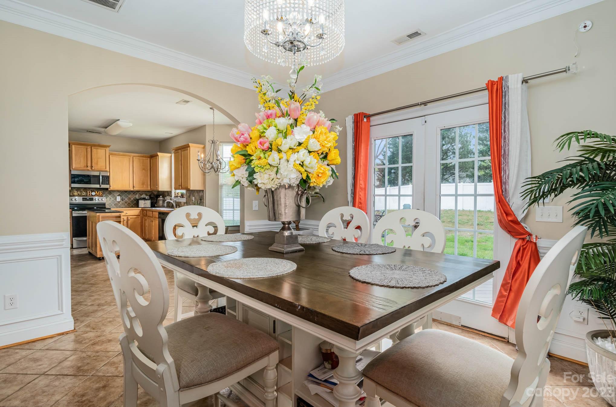 2719 Spring Breeze Way Monroe, NC 28110 - Photo 13 of 25 a view of a dining room with furniture a chandelier and wooden floor