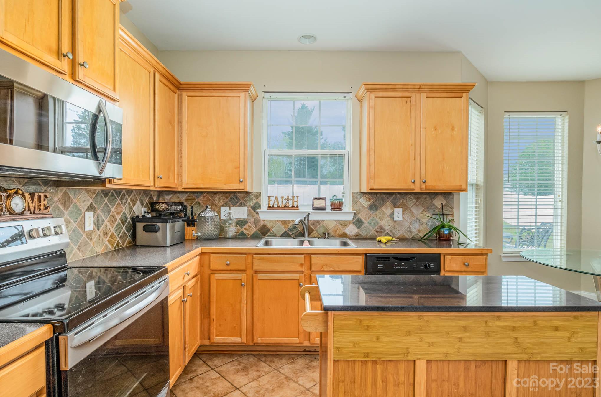 2719 Spring Breeze Way Monroe, NC 28110 - Photo 15 of 25 a kitchen with stainless steel appliances granite countertop a sink and a counter space