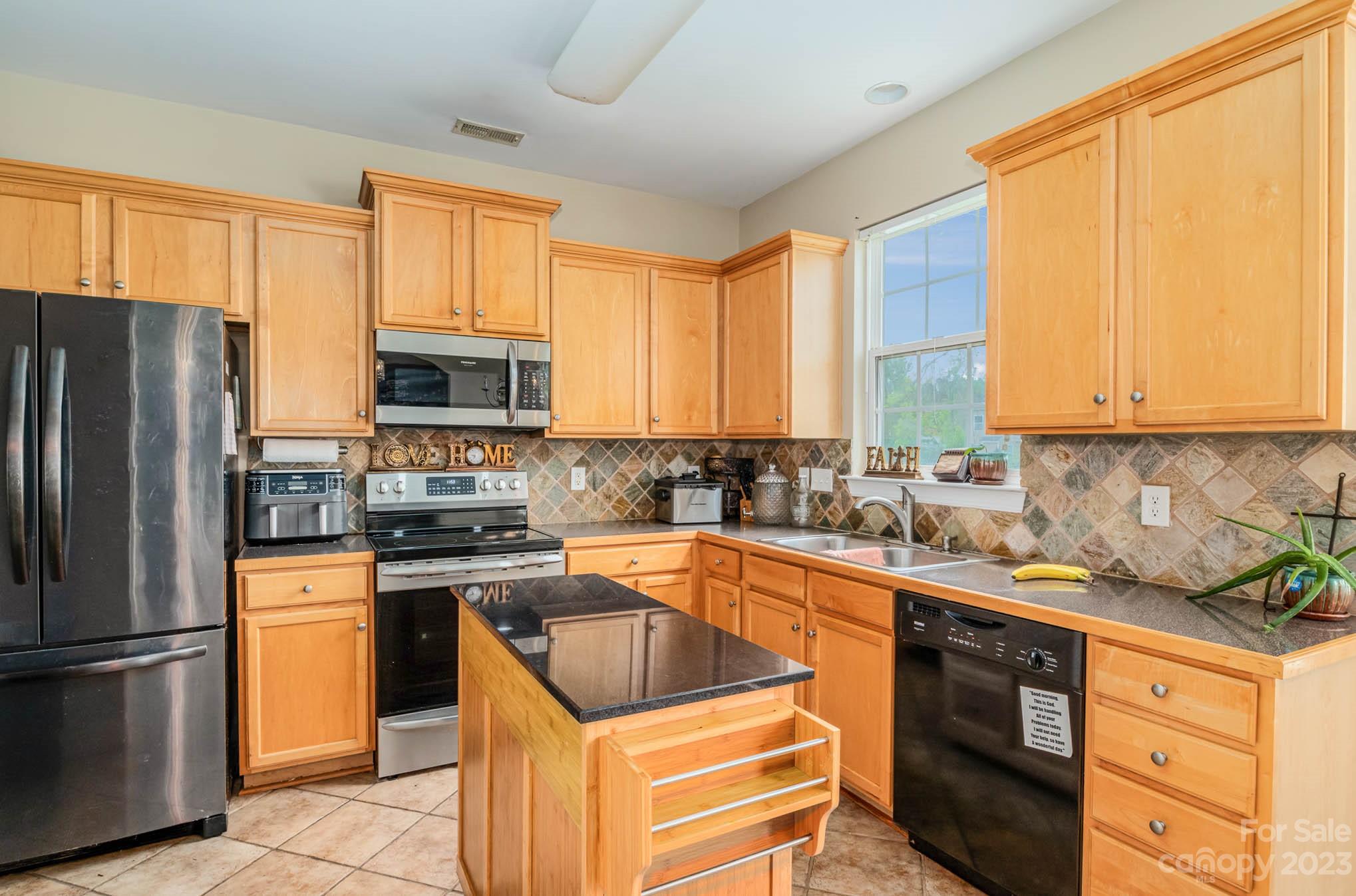 2719 Spring Breeze Way Monroe, NC 28110 - Photo 3 of 25 a kitchen with stainless steel appliances a stove a sink a refrigerator cabinets and a window