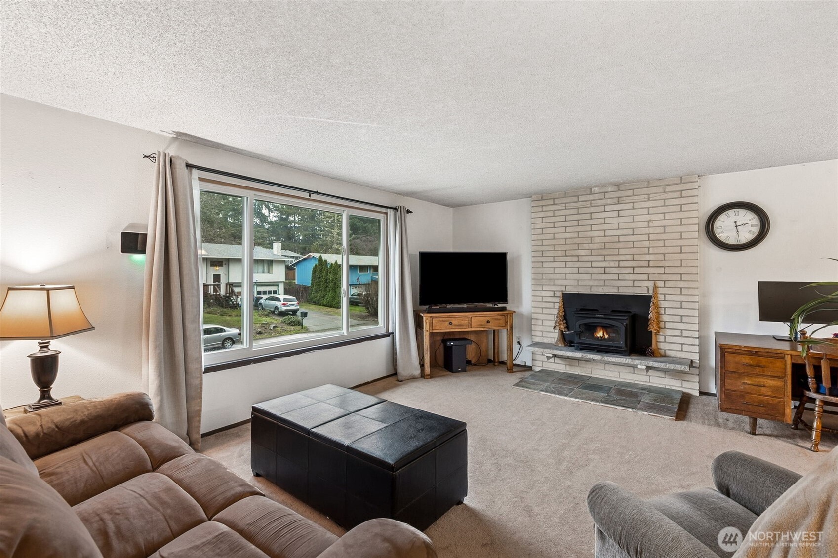 7825 Husky Way Southeast Olympia, WA 98503 - Photo 6 of 22 a living room with furniture a flat screen tv and a fireplace