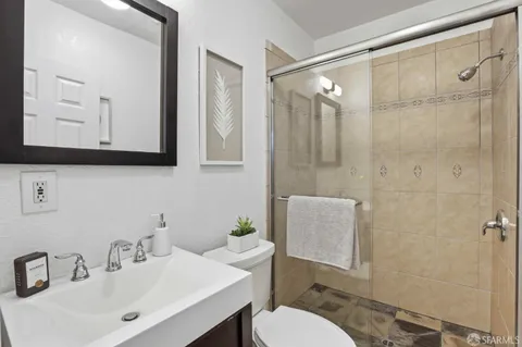 a bathroom with a sink a toilet and shower
