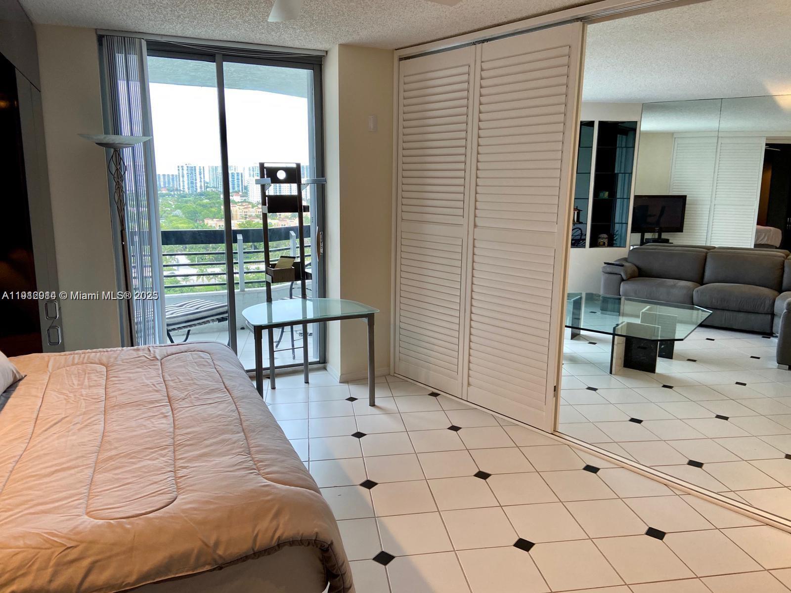 3530 Mystic Pointe Drive, Unit 1708 Aventura, FL 33180 - Photo 11 of 27 a bedroom with a bed and a large window