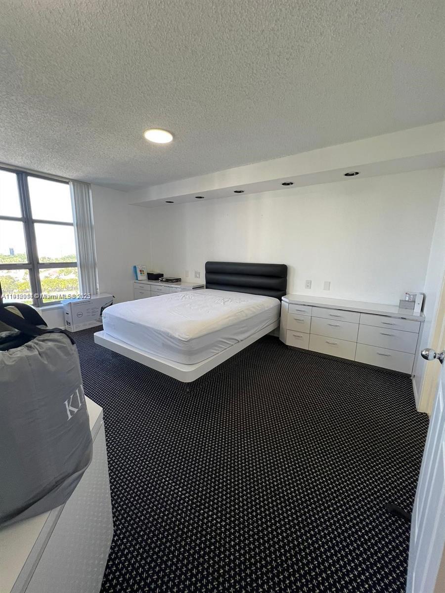 3530 Mystic Pointe Drive, Unit 1708 Aventura, FL 33180 - Photo 12 of 27 a bedroom with a bed and a window