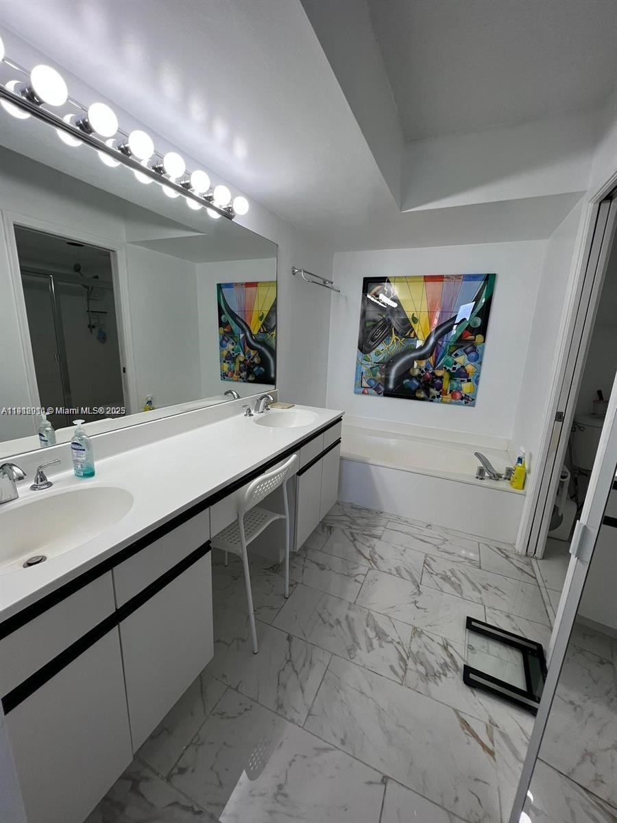 3530 Mystic Pointe Drive, Unit 1708 Aventura, FL 33180 - Photo 13 of 27 a bathroom with a sink double vanity and a mirror