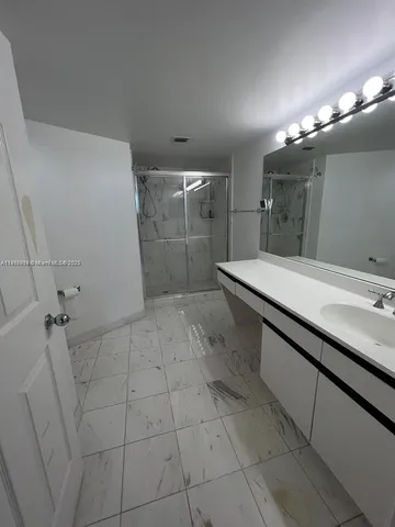 a bathroom with a sink a toilet a mirror and shower