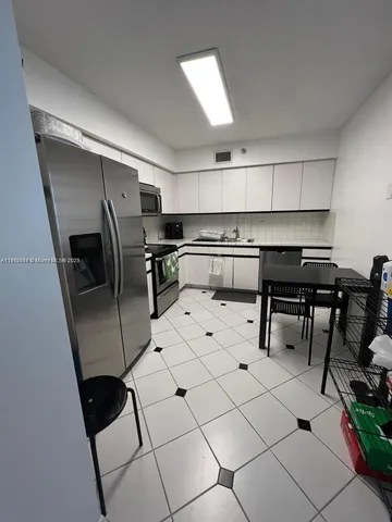 a kitchen with stainless steel appliances kitchen island granite countertop a sink and cabinets