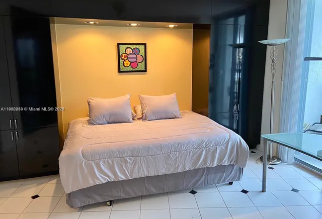 a bedroom with a bed and a painting on the wall