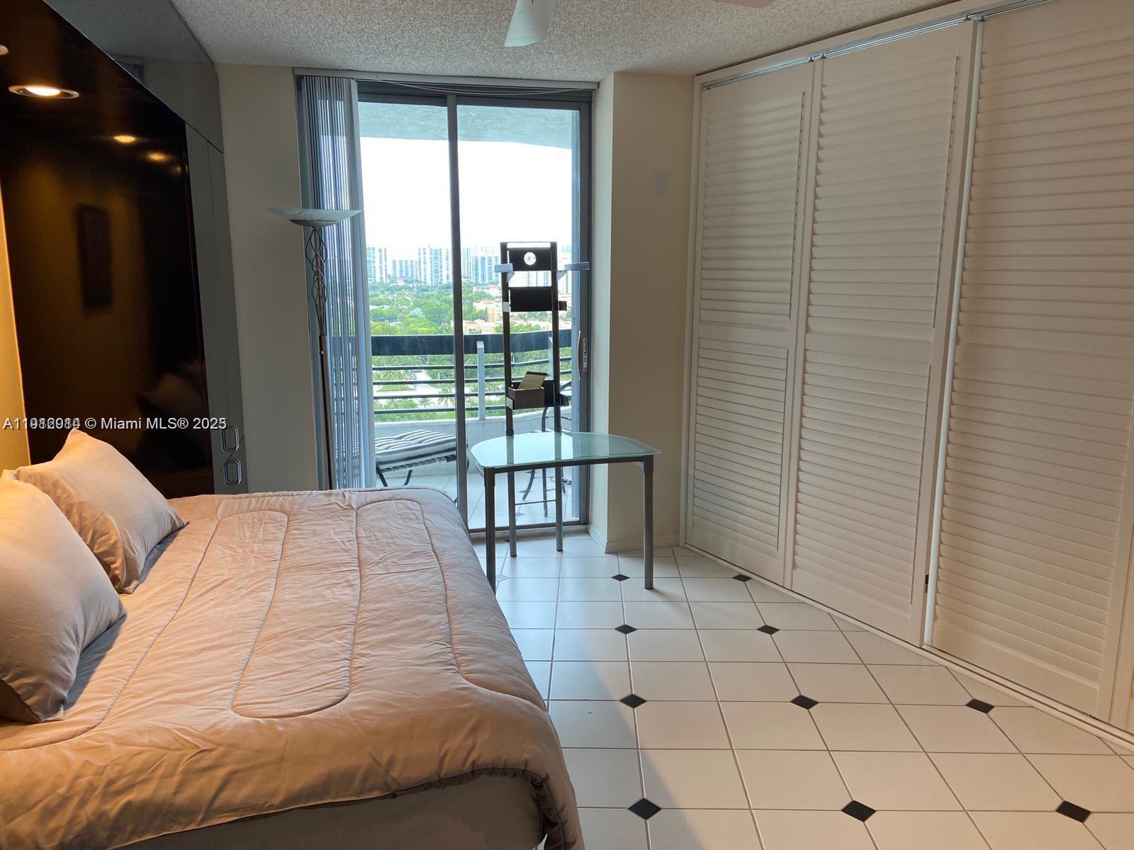 3530 Mystic Pointe Drive, Unit 1708 Aventura, FL 33180 - Photo 10 of 27 a bedroom with a bed and a large window