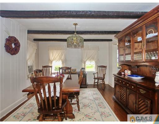 88 Halsey Reed Road Cranbury, NJ 08512 - Photo 6 of 18 a dining room with wooden floor a chandelier a wooden table and chairs