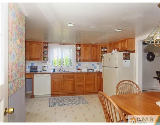 88 Halsey Reed Road Cranbury, NJ 08512 - Photo 10 of 18 a kitchen with refrigerator a sink a stove and wooden cabinets