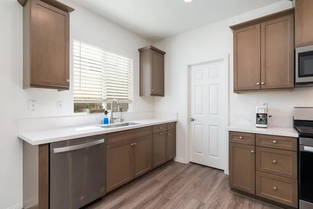a kitchen with stainless steel appliances granite countertop a sink stove and cabinets