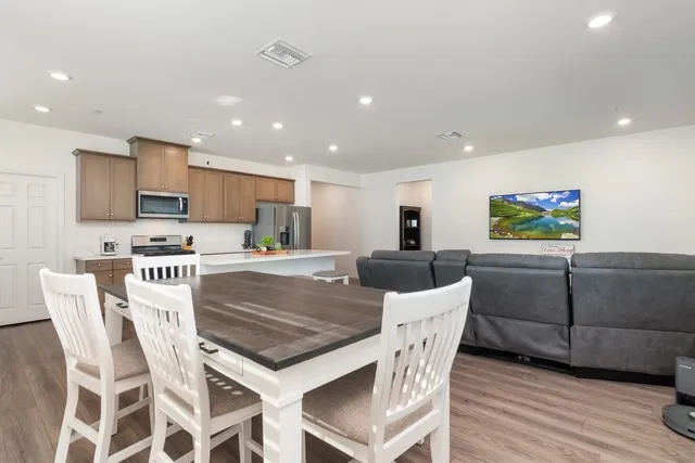 a view of kitchen with stainless steel appliances granite countertop a table and chairs