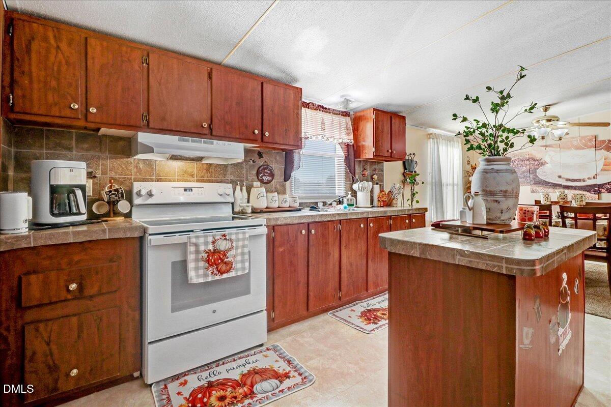4305 Chinook Road Wilson, NC 27893 - Photo 24 of 37 a kitchen with stainless steel appliances granite countertop a stove a sink dishwasher and cabinets with wooden floor