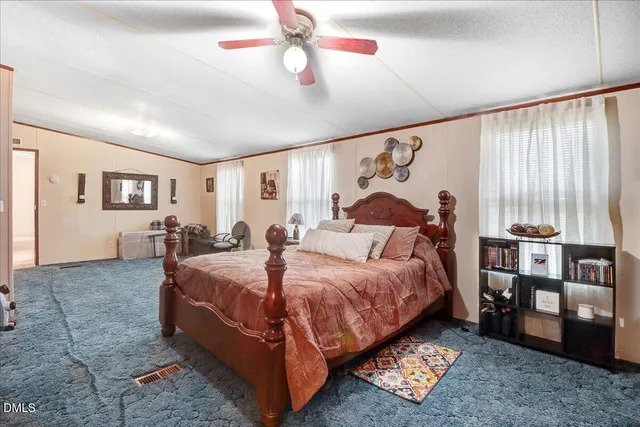 a spacious bedroom with a bed and a flat screen tv