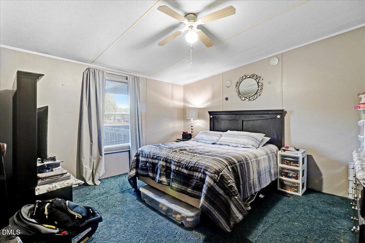 4305 Chinook Road Wilson, NC 27893 - Photo 34 of 37 a bedroom with a bed and a chandelier
