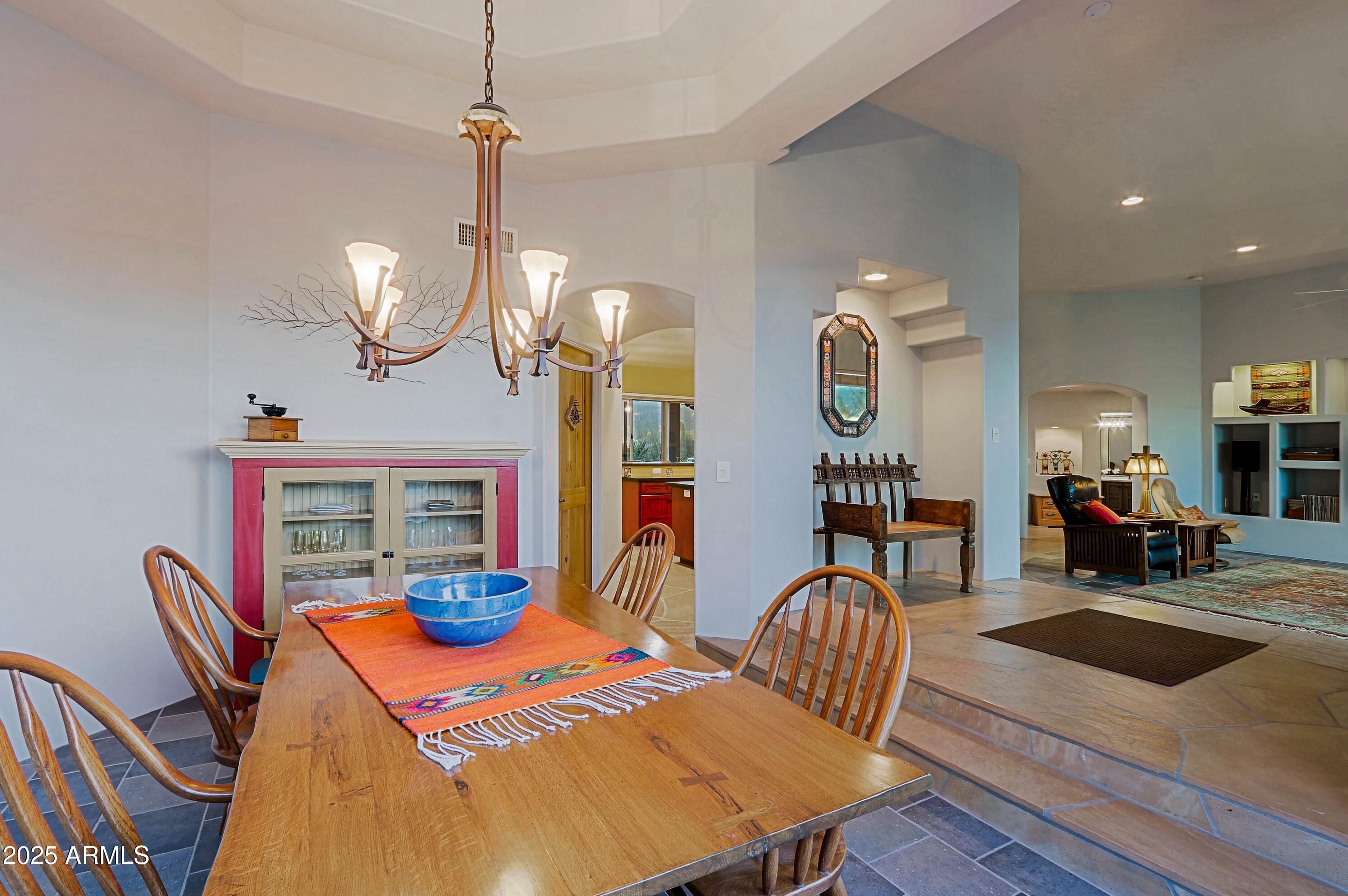 41840 North Spur Cross Road Cave Creek, AZ 85331 - Photo 17 of 67 a view of a dining room with furniture a chandelier and wooden floor