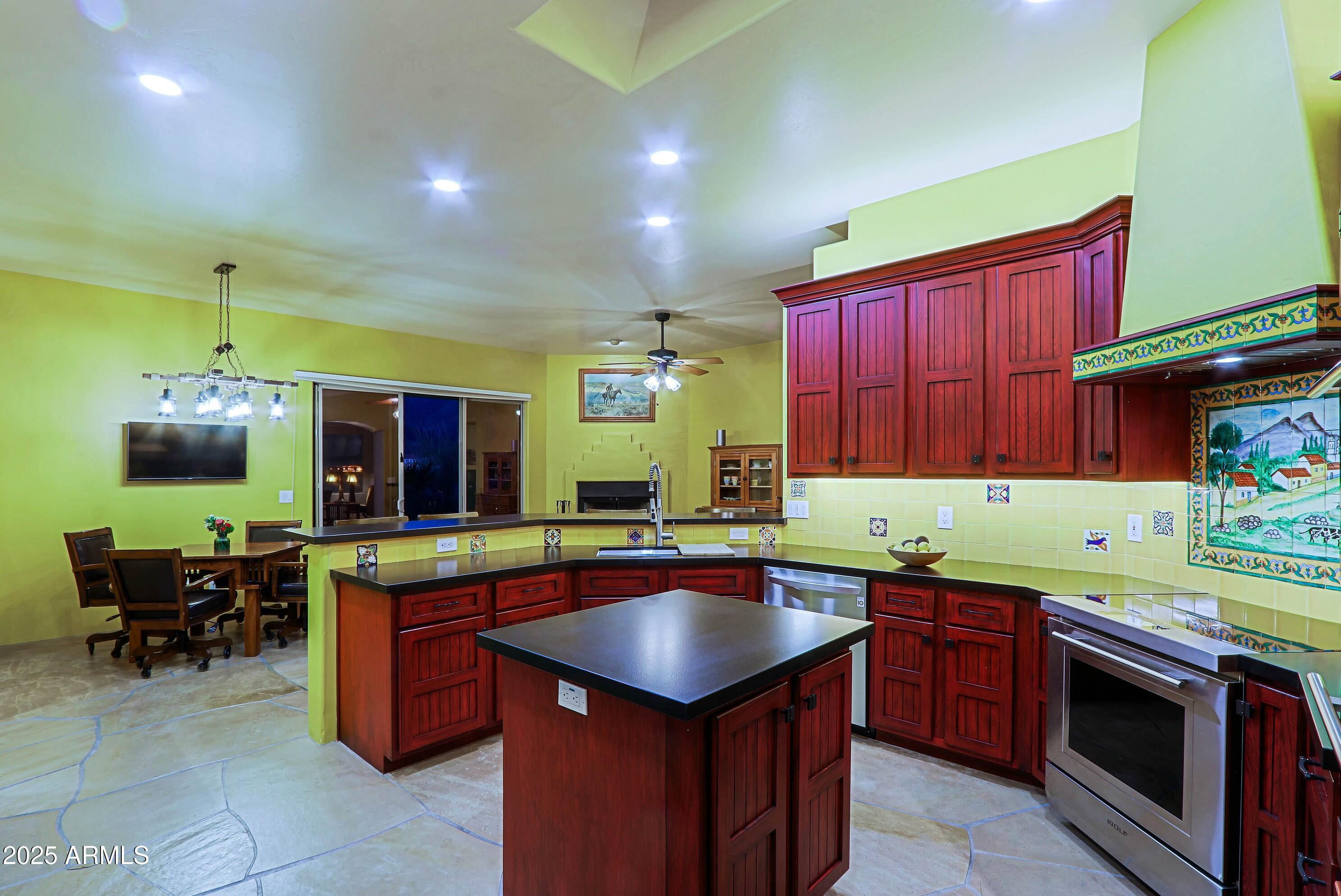 41840 North Spur Cross Road Cave Creek, AZ 85331 - Photo 19 of 67 a kitchen that has a sink a stove counter top space and a chair in it