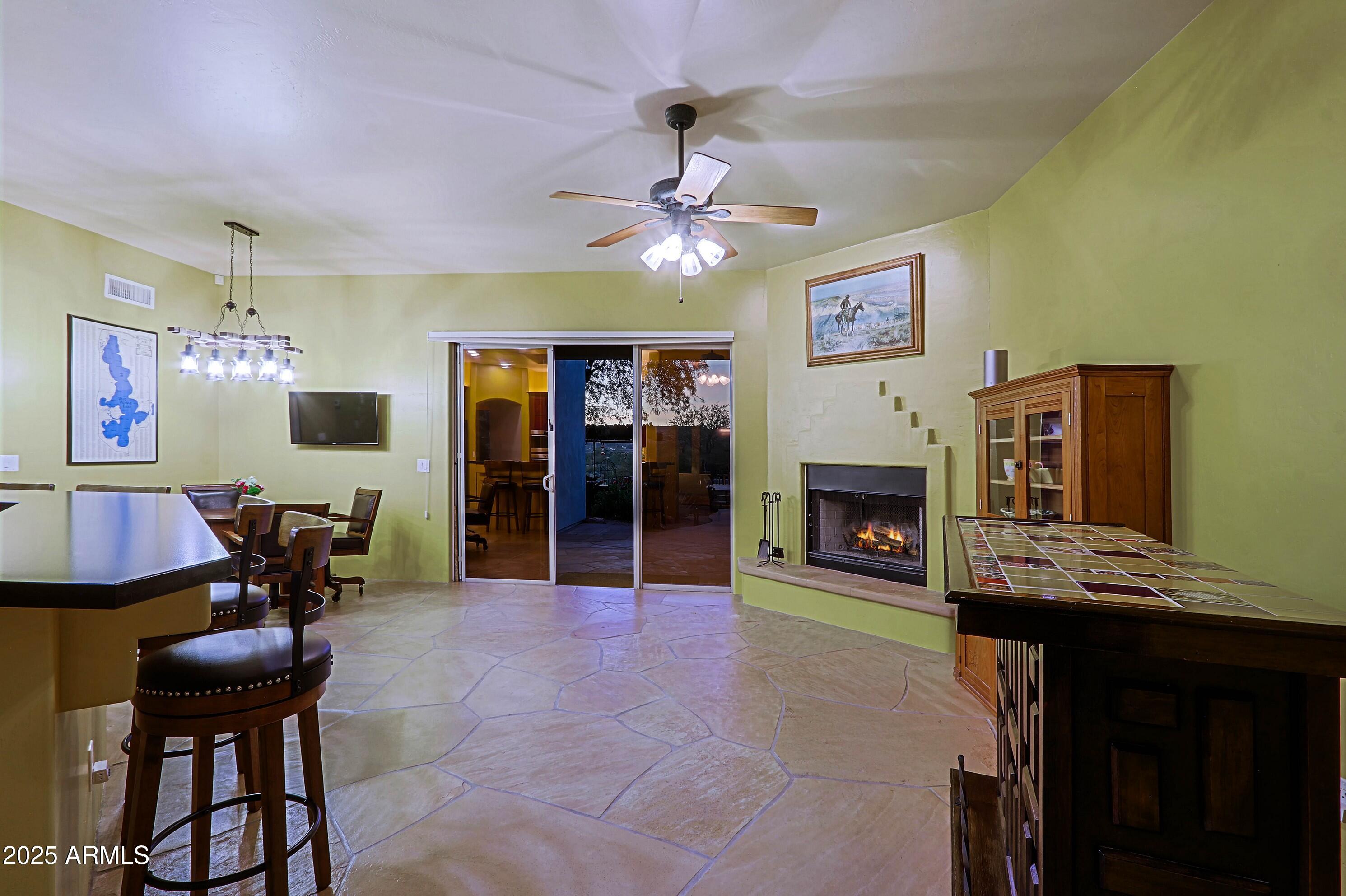 41840 North Spur Cross Road Cave Creek, AZ 85331 - Photo 26 of 67 a living room with furniture a fireplace and a flat screen tv