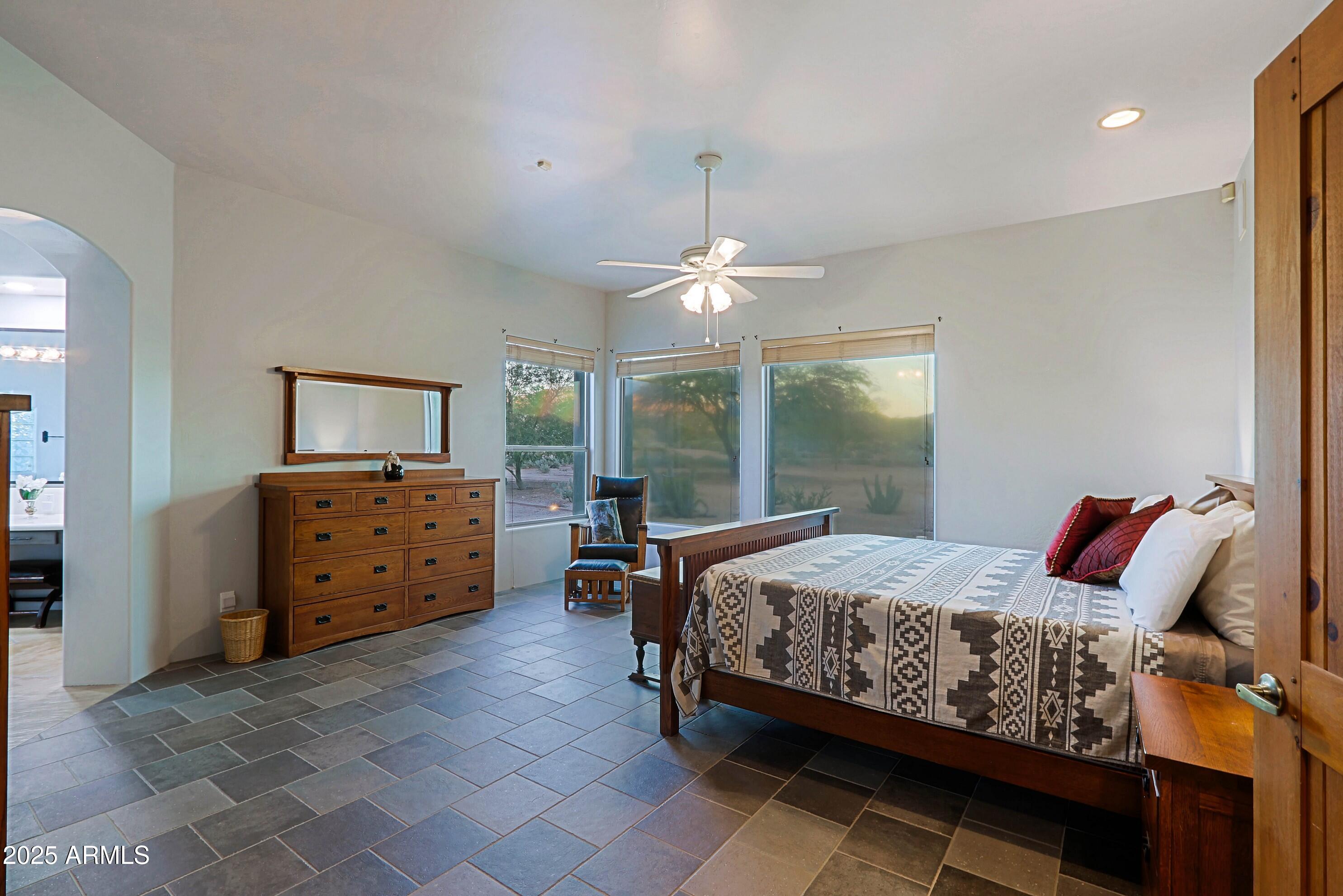 41840 North Spur Cross Road Cave Creek, AZ 85331 - Photo 48 of 67 a bedroom with a bed and a chandelier